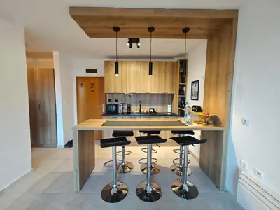 a kitchen with a center island with bar stools at Friendly apartment -top location in Bansko