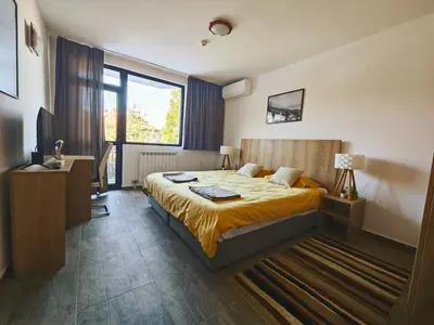 a hotel room with a bed and a window at Friendly apartment -top location in Bansko