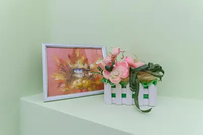 a picture on a shelf with pink flowers and a picture at 1-bedroom City Center secret gem in Plovdiv