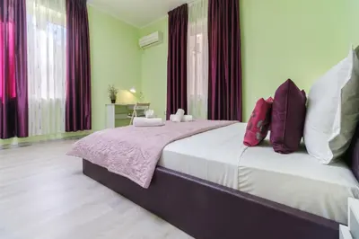 a bedroom with a large bed with purple and white pillows at 1-bedroom City Center secret gem in Plovdiv