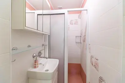 a white bathroom with a sink and a shower at 1-bedroom City Center secret gem in Plovdiv