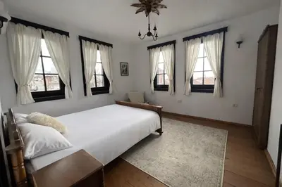 a bedroom with a large white bed with windows at Large Cosy House by a Forest - Treehouse, BBQ, Fireplace & Mountain in Sopot