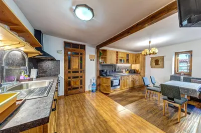 a kitchen with wooden floors and a dining room with a table at Valkanovi House in Pamporovo