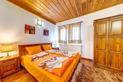 a bedroom with a bed and a wooden ceiling at Valkanovi House in Pamporovo