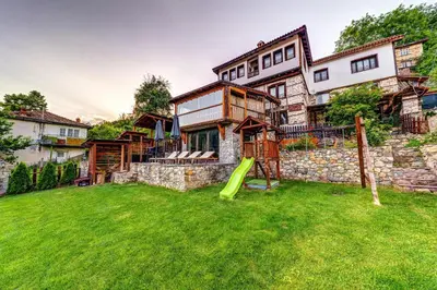 a house with a playground in the yard at Valkanovi House in Pamporovo