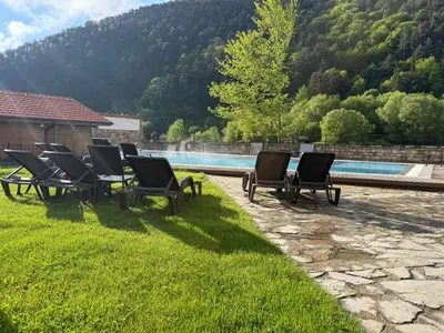 a row of chairs sitting next to a swimming pool at Мия4 Спа хотел Свети Спас in Velingrad