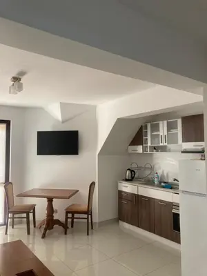a kitchen and dining room with a table and chairs at Апартамент Пирин in Sandanski