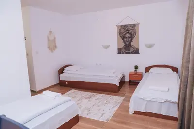 a room with two beds and a painting on the wall at BASSO Guest Rooms in Perushtitsa