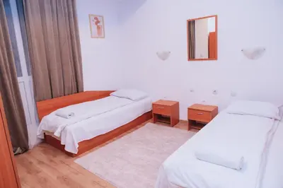 a room with two beds and a mirror at BASSO Guest Rooms in Perushtitsa
