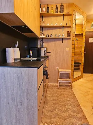 a kitchen with a counter and a stool in a room at Ski In Out Aparthotel Kosara in Bansko