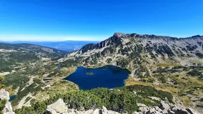 an aerial view of a mountain with a blue lake at Ski In Out Aparthotel Kosara in Bansko