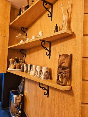 a room with wooden shelves with cups and a coffee maker at Ski In Out Aparthotel Kosara in Bansko