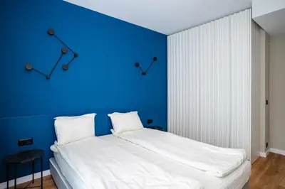 a bedroom with a blue wall and a bed at Aviva Living by Flat Mаnager in Sofia