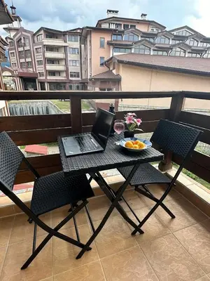 a laptop computer sitting on a table on a balcony at Cozy Mountain Apartment in Bansko