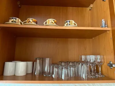 a wooden shelf with glasses and cups on it at Cozy Mountain Apartment in Bansko