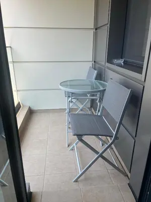 a small table and a chair in a room at FREESIA apartment with underground parking in Sofia