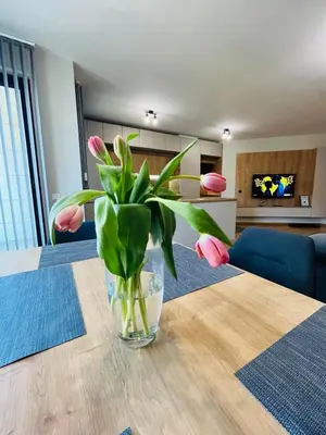 a vase with pink flowers sitting on a table at FREESIA apartment with underground parking in Sofia