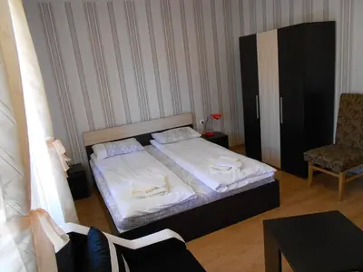 a small bedroom with a bed and a chair at Guest House Tsenovi in Koprivshtitsa