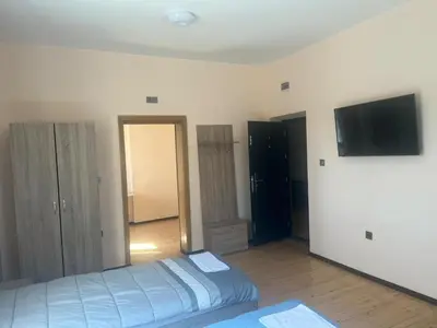 a bedroom with a bed and a flat screen tv at Къща за гости Савана, Пловдив,Plovdiv, летище Пловдив, Plovdiv Airport,Ягодово in Yagodovo