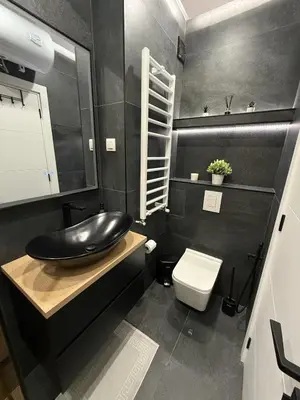 a black bathroom with a sink and a toilet at AveNew Luxury Apartment 3 in Sofia