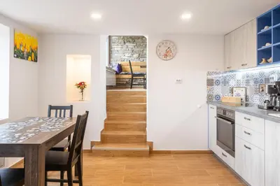 a kitchen and dining room with a table and a staircase at Casa Lavandula in Sredno Gradishte
