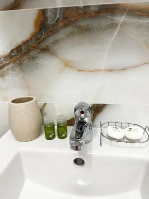 a sink with a faucet and two candles on it at Bibi Central Apartment Plovdiv in Plovdiv