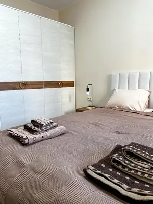 a bedroom with a bed with two towels on it at Bibi Central Apartment Plovdiv in Plovdiv