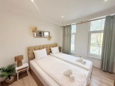 a bedroom with a large bed with white sheets at Center Apartments The Quiet Luxury 1 in Plovdiv