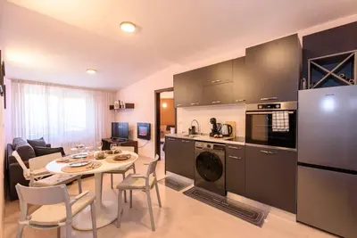a kitchen and living room with a table and chairs at 2BR Apartment Near Gondola by SI Stay in Bansko
