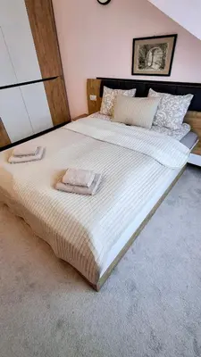 a large bed with two towels on top of it at 2BR Apartment Near Gondola by SI Stay in Bansko