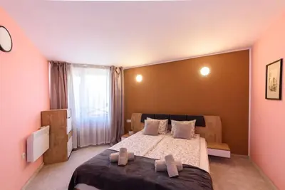 a bedroom with a large bed with two towels on it at 2BR Apartment Near Gondola by SI Stay in Bansko