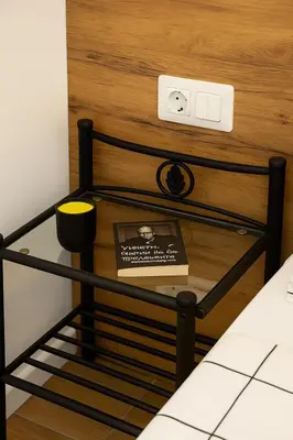 a book on a glass table next to a bed at Cozy and comfortable northern apartment, Kapana district, Plovdiv, Center in Plovdiv