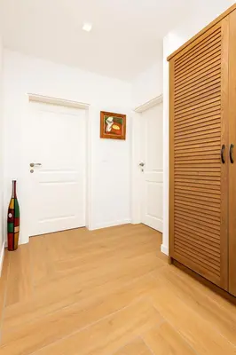 a hallway with white walls and a wooden door at Cozy and comfortable northern apartment, Kapana district, Plovdiv, Center in Plovdiv