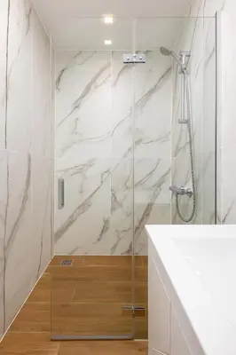 a bathroom with a shower and a white marble wall at Cozy and comfortable southern apartment, Kapana district, Plovdiv, Center in Plovdiv