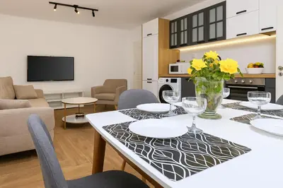 a living room with a dining room table with yellow flowers at Cozy and comfortable southern apartment, Kapana district, Plovdiv, Center in Plovdiv