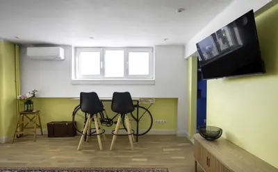 a living room with two chairs and a table and a tv at Best Views from Top Central Cozy 1-Bedroom Flat by Flat Mаnager in Sofia