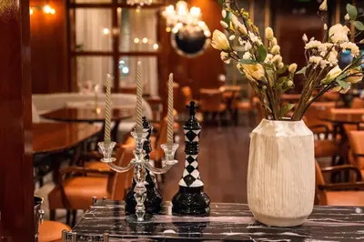 a table with two candles and a vase with flowers at Hotel Royal Plovdiv in Plovdiv