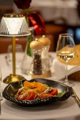 a plate of food on a table with a lamp at Hotel Royal Plovdiv in Plovdiv