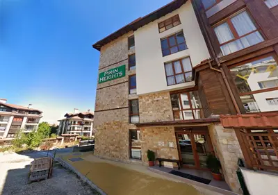a building with a river in front of it at Pirin Heights Apartment 200m from SKI ROAD in Bansko