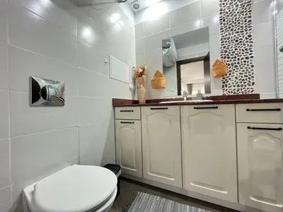 a white bathroom with a toilet and a sink at Luxury flat F218 in Bansko