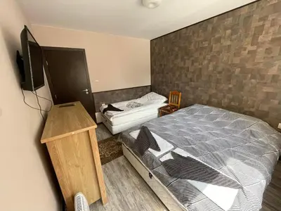 a bedroom with a bed and a tv on a wall at Комплекс Свети Георги in Pamporovo