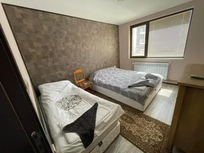 a small bedroom with two beds and a table at Комплекс Свети Георги in Pamporovo
