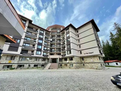 a large apartment building in front of a parking lot at St Georgi in Pamporovo