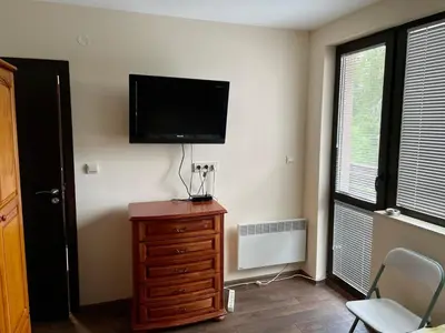 a room with a television on a wall with a dresser at St Georgi in Pamporovo