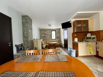 a kitchen and a living room with a table and chairs at St Georgi in Pamporovo