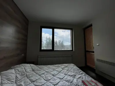 a bedroom with a bed and two windows at St Georgi in Pamporovo