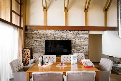 a dining room with a table and chairs and a fireplace at Pirin Golf Villa Relax in Razlog