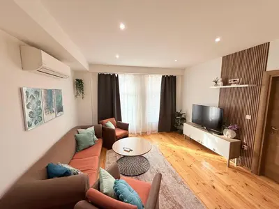 a living room with a couch and a tv at Central 2 Bedroom Apartments The Quiet Luxury 3 in Plovdiv