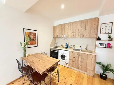 a kitchen with wooden cabinets and a table and a sink at Central 2 Bedroom Apartments The Quiet Luxury 3 in Plovdiv