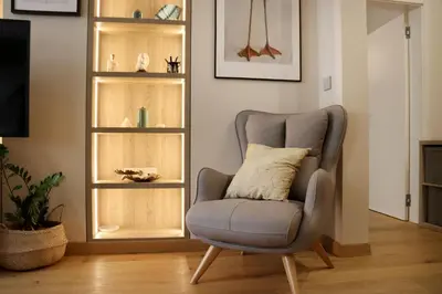 a gray chair with a pillow in a living room at NEW Glamours Central Suite with Elevator in Sofia